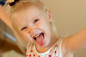 Happy toddler girl sticking out her tongue 